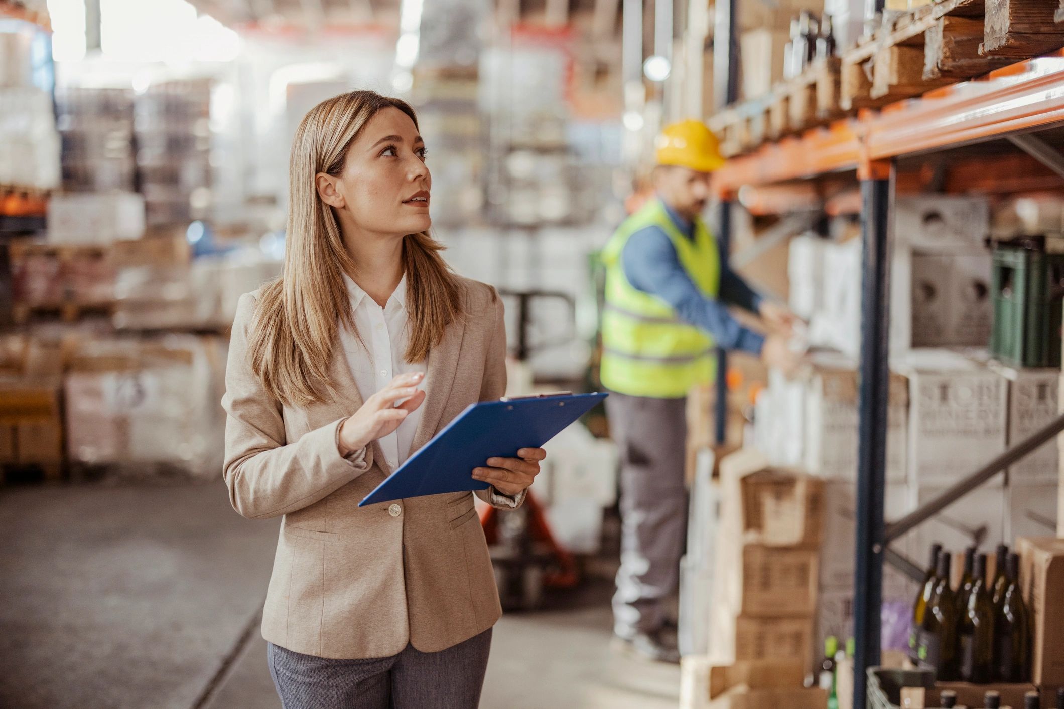 Warehouse supervisor reviewing inventory on a clipboard